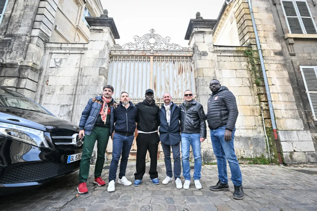 Sadio Mané (centro), rodeado pelos corretores imobiliários Barth Sébastien Pillard (esquerda) e Cheikh Sylla (direita), em frente ao Hôtel des Méloizes | Foto: Pierrick DELOBELLE